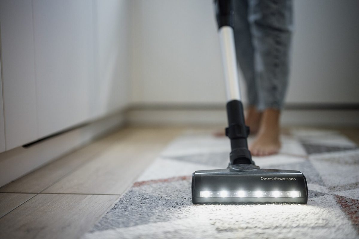 A person vacuuming the floor in a home