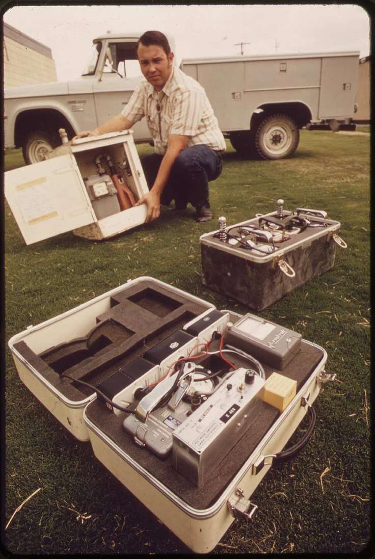 An EPA technician holding a portable air sampler in a 1970s National Archives photo