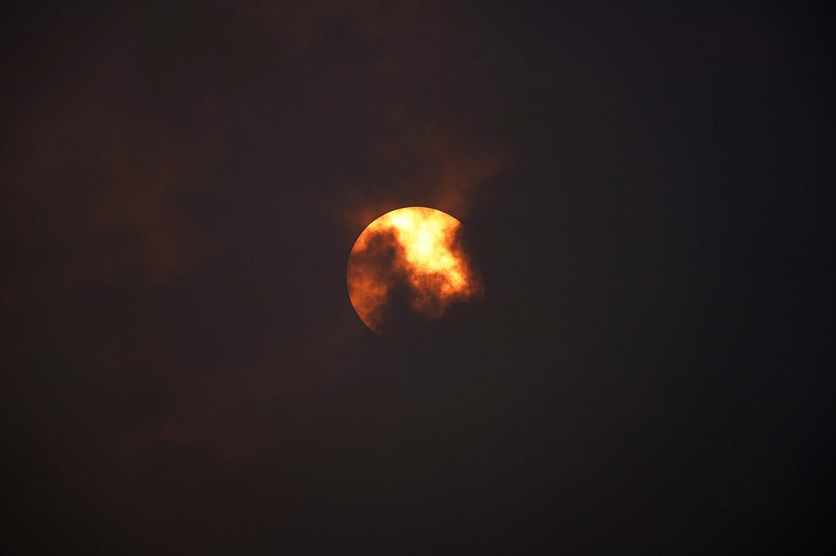 The sun dimmed and reddened through a layer of wildfire smoke